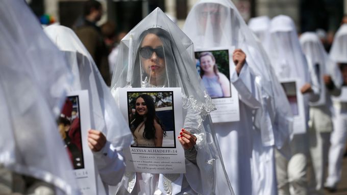 Účastníci washingtonské demonstrace pochodují s obrazy obětí střelby.