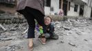 A boy holds his mother's leg as he cries in front of their damaged house after a strong 6.6 magnitude earthquake at Longmen village, Lushan county in Ya'an, Sichuan province April 21, 2013. Rescuers poured into a remote corner of southwestern China on Sunday as the death toll from the country's worst earthquake in three years climbed to 164 with more than 6,700 injured, state media said. REUTERS/Jason Lee (CHINA - Tags: DISASTER ENVIRONMENT TPX IMAGES OF THE DAY) Published: Dub. 21, 2013, 4:28 dop.