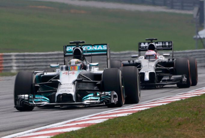 Mercedes Formula One driver Lewis Hamilton of Britain drives ahead of McLaren Formula One driver Jenson Button of Britain during the second practice session of the Malays