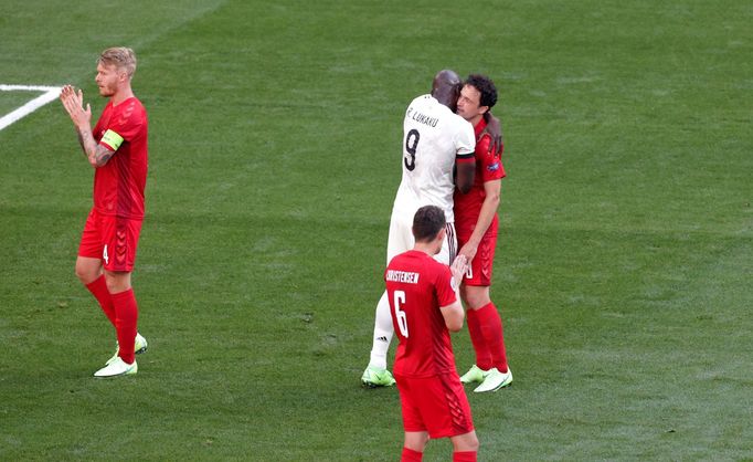 Belgický útočník Romelu Lukaku objímá Thomase Delaneyho z Dánska, který v 10. minutě zakopl míč, aby mohli hráči potleskem vzdát hold Christianu Eriksenovi