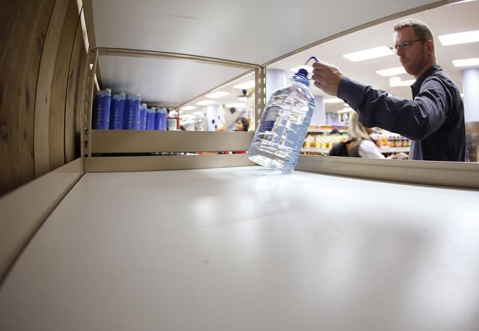 A shopper takes the last bottle of water off the shelf at Trader Joe's supermarket in New York October 28, 2012. The approach of Hurricane Sandy - expected to come ashore Monday night - set off a scramble this weekend for supplies from Virginia to New England, causing long lines at gas stations, bare shelves at hardware and home-supply shops, and a run on bread, bottled water and canned foods at grocery stores.. REUTERS/Carlo Allegri (UNITED STATES - Tags: ENVIRONMENT FOOD) Published: Říj. 28, 2012, 5:43 odp.