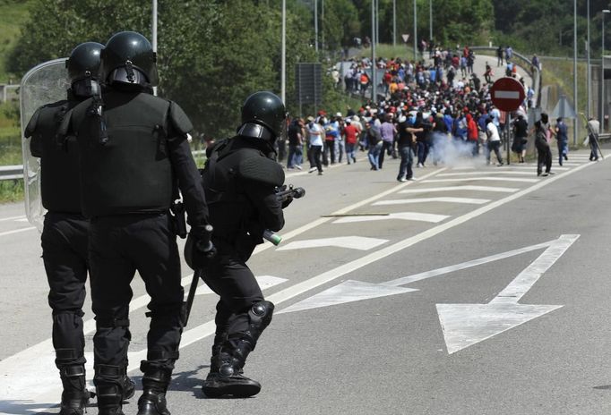 Spanish Civil Guard officers in full riot gear shoot rubber bullets during clashes with coal miners protesting against government spending cuts in the mining sector in the northern Spanish village of Campomanes May 30, 2012. REUTERS/Eloy Alonso (SPAIN - Tags: CIVIL UNREST BUSINESS EMPLOYMENT) Published: Kvě. 30, 2012, 1:40 odp.