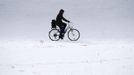 A man rides his bicycle through the snow along the embankment of the river Spree near the governmental district in Berlin, March 12, 2013. REUTERS/Fabrizio Bensch (GERMANY - Tags: ENVIRONMENT) Published: Bře. 12, 2013, 12:28 odp.