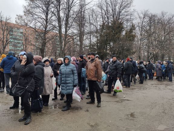 Obyvatelé ostřelovaného Charkova stojí frontu před místní nemocnicí, která distribuuje jídlo.