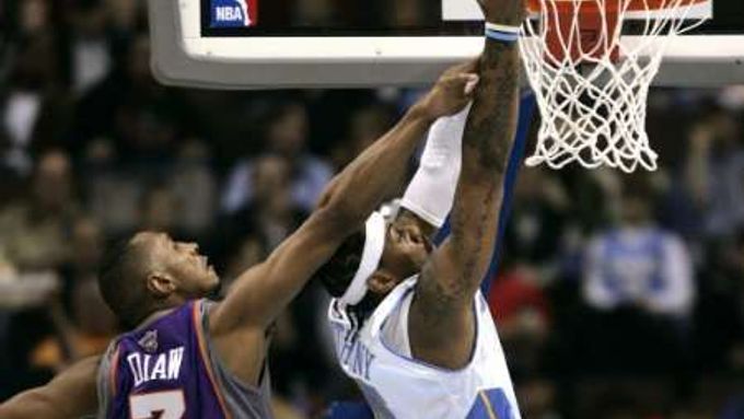 Boris Diaw z Phoenixu Suns (vlevo) fauluje denverského Carmela Anthonyho při pokusu o smeč ve druhé čtvrtině zápasu NBA.