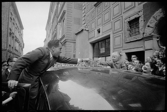 Holčička ve Varšavě podává americkému viceprezidentovi Richardu Nixonovi přes střechu auta kytku.