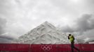 A worker walks past the Olympic basketball arena in Olympic Park, Stratford, east London, July 19, 2012. The 2012 London Olympic Games will begin in just over a week. REUTERS/Andrew Winning (BRITAIN - Tags: SPORT OLYMPICS BASKETBALL) Published: Čec. 19, 2012, 1:31 odp.