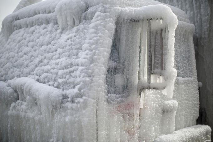 Trucks sit encased in ice following a warehouse fire, which is still burning and started on Tuesday night in Chicago January 24, 2013. Fire department officials said it is the biggest fire the department has had to battle in years and one-third of all Chicago firefighters were on the scene at one point or another trying to put out the flames. REUTERS/John Gress (UNITED STATES - Tags: DISASTER ENVIRONMENT) Published: Led. 24, 2013, 10:28 odp.