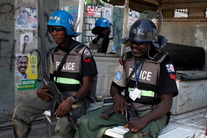 Nigerijští policisté hlídkují u provizorní volební místnosti v Port-au-Prince.