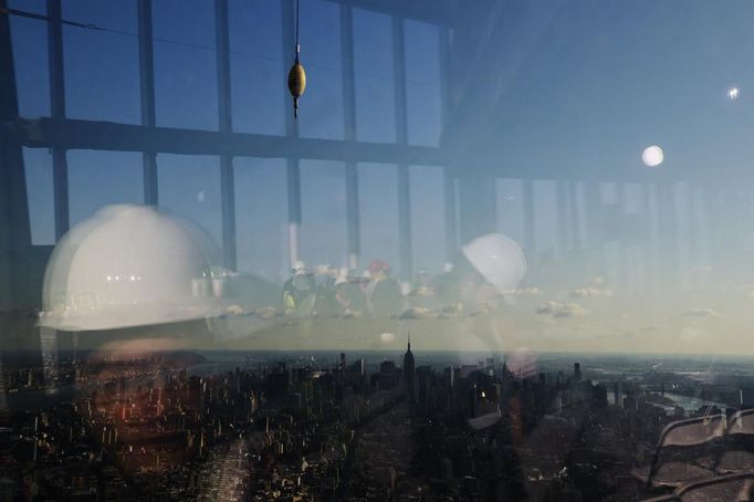 Members of the media are reflected in the windows of the 100th floor observation deck in One World Trade Center before a press conference in New York, April 2, 2013. Port Authority officials unveiled Tuesday the stunning view from the top of One World Trade Center, a 360-degree eagle�s eye panorama that will instantly become one of the city�s premiere tourist attractions when it is completed in 2015. REUTERS/Lucas Jackson (UNITED STATES - Tags: CITYSPACE BUSINESS CONSTRUCTION) Published: Dub. 2, 2013, 4:37 odp.