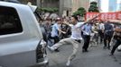 A demonstrator kicks a Japanese-brand car during a protest in Chongqing, September 15, 2012. Thousands of Chinese besieged the Japanese embassy in Beijing on Saturday, hurling rocks, eggs and bottles with protests reported in other major cities in China amid growing tension between Asia's two biggest economies over a group of disputed islands. Part of the Chinese characters on the banner (R) reads, "Boycott Japanese products, love my China." REUTERS/Stringer (CHINA - Tags: POLITICS) CHINA OUT. NO COMMERCIAL OR EDITORIAL SALES IN CHINA