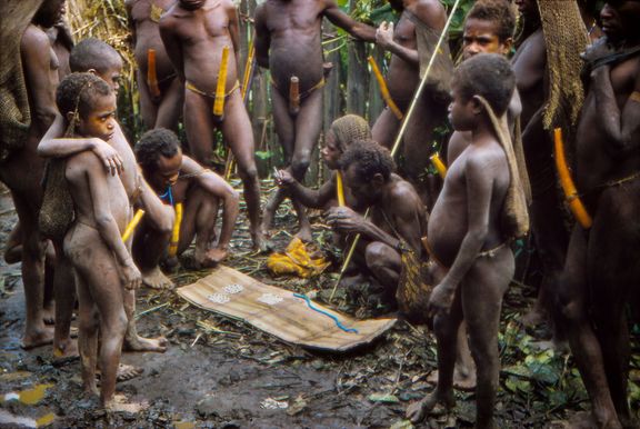 Skupina vesničanů seskupená kolem věna (cena vyčíslená v mušlích kauri za nevěstu), jež je položeno na podložce za zemi, 1959.