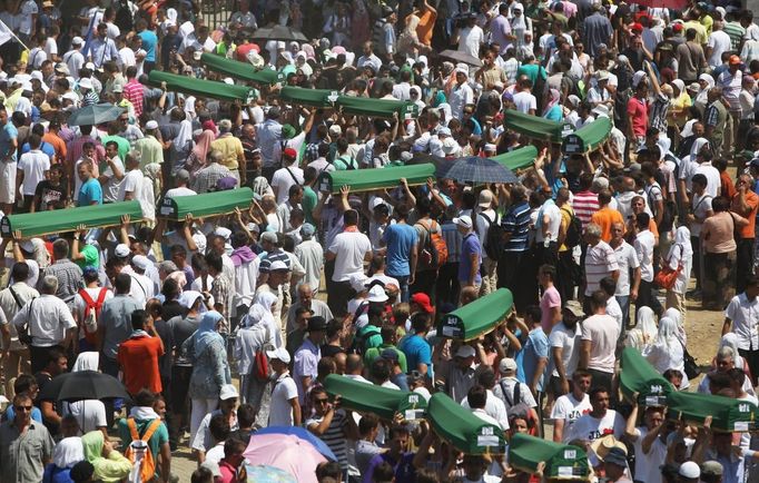 Bosnia Muslims carry coffins at the Memorial Center in Potocari during a mass burial, near Srebrenica July 11, 2012. The bodies of 520 recently identified victims of the Srebrenica massacr is buried on July 11, the anniversary of the massacre when Bosnian Serb forces commanded by Ratko Mladic slaughtered 8,000 Muslim men and boys and buried them in mass graves, in Europe's worst massacre since World War Two. REUTERS/Dado Ruvic (BOSNIA - Tags: CONFLICT OBITUARY SOCIETY)