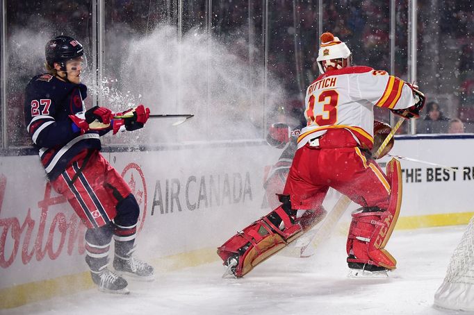 NHL 2019/2020, Heritage Classic, Calgary Flames - Winnipeg Jets: David Rittich rozehrává puk.