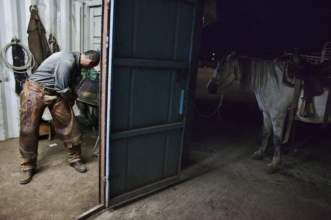 Amit, an Israeli cowboy, gets dressed for work in the early morning on a ranch just outside Moshav Yonatan, a collective farming community, about 2 km (1 mile) south of the ceasefire line between Israel and Syria in the Golan Heights May 21, 2013. Cowboys, who have been running the ranch on the Golan's volcanic rocky plateau for some 35 years, also host the Israeli military, who use half of the cattle farm, 20,000 dunams (5,000 acres), as a live-fire training zone. Israel captured the Golan Heights from Syria in the 1967 Middle East war and annexed the territory in 1981, a move not recognized internationally. Picture taken May 21, 2013. REUTERS/Nir Elias (ENVIRONMENT ANIMALS SOCIETY) ATTENTION EDITORS: PICTURE 24 OF 27 FOR PACKAGE 'COWBOYS OF THE GOLAN HEIGHTS' SEARCH 'COWBOY GOLAN' FOR ALL IMAGES Published: Kvě. 29, 2013, 10:08 dop.