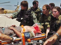 Izraelští vojáci nakládají do vrtulníku kolegu, který byl zraněn při raketovém útoku Hizballáhu na Haifu.
