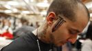 A client shows his new knife tattoo, which appears on both sides of his face, at the National Tattoo Association Convention in Cincinnati, Ohio April 14, 2012. The hobby of collecting tattoos has exploded into the mainstream of society with tattoo conventions and festivals held year-round across the United States and the world. Picture taken April 14, 2012. REUTERS/Larry Downing (UNITED STATES - Tags: SOCIETY) ATTENTION EDITORS PICTURE 12 OF 31 FOR PACKAGE 'ADDICTED TO THE NEEDLE' TO FIND ALL PICTURES SEARCH 'ADDICTED NEEDLE' Published: Čer. 29, 2012, 12:59 odp.