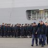 Russian sailors walk in front of the Mistral-class helicopter carrier Vladivostok at the STX Les Chantiers de l'Atlantique shipyard site in Saint-Nazaire