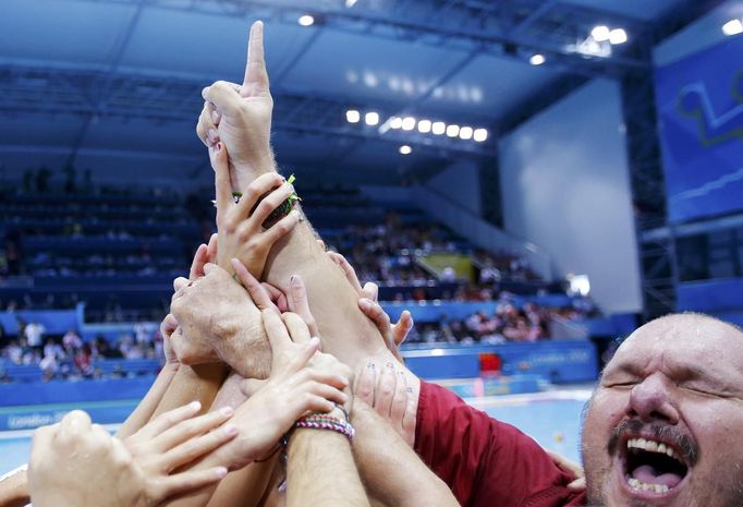 Trenér maďarských házenkářek Andras Meresz oslavuje spolu se svými svěřenkyněmi vítězství v utkání proti týmu Ruska.