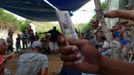 A man holds Cuban banknotes for betting at an illegal cock fighting arena set up at the entrance of a military anti-aircraft bunker on the outskirts of Havana June 16, 2012. In Cuba, it's legal to own cocks, it's legal to train them to fight and it's legal to fight them, but since the 1959 Cuban Revolution all forms of betting and gambling have been strictly forbidden. But betting on cock fights is an activity so popular among Cubans that stopping it would pose a huge challenge for the authorities and would be counterproductive to keeping law and order. Picture taken June 16, 2012. REUTERS/Desmond Boylan (CUBA - Tags: SOCIETY ANIMALS) ATTENTION EDITORS PICTURE 16 OF 23 FOR PACKAGE 'BETTING ON CUBA'S FIGHTING COCKS' . TO FIND ALL PICTURES SEARCH 'FIGHTING COCKS' Published: Čec. 2, 2012, 12:32 odp.