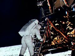 Edwin E. "Buzz" Aldrin Jr. sestupuje ze schodů lunárního modulu, připravuje se k procházce po Měsíci.