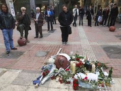 Studentka stojí v Athénách u provizorního pomníku na místě, kde policista zastřelil patnáctiletého Alexandra Grigoropoulose