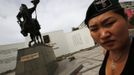 Uranjargal, a leader of the Mongolian neo-Nazi group Tsagaan Khass, stands next to a statue of Chingunjav, a Mongolian national hero, in Ulan Bator June 22, 2013. The group has rebranded itself as an environmentalist organisation fighting pollution by foreign-owned mines, seeking legitimacy as it sends Swastika-wearing members to check mining permits. Over the past years, ultra-nationalist groups have expanded in the country and among those garnering attention is Tsagaan Khass, which has recently shifted its focus from activities such as attacks on women it accuses of consorting with foreign men to environmental issues, with the stated goal of protecting Mongolia from foreign mining interests. This ultra-nationalist group was founded in the 1990s and currently has 100-plus members. Picture taken June 22, 2013. REUTERS/Carlos Barria (MONGOLIA - Tags: SOCIETY POLITICS) ATTENTION EDITORS: PICTURE 10 OF 25 FOR PACKAGE 'MONGOLIA'S ENVIRONMENTAL NEO-NAZIS'. TO FIND ALL IMAGES SEARCH 'TSAGAAN KHASS' Published: Čec. 2, 2013, 9:58 dop.