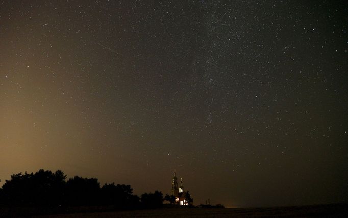 Meteor streaks across the sky over an Orthodox church during the Perseid meteor shower near the village of Malashki