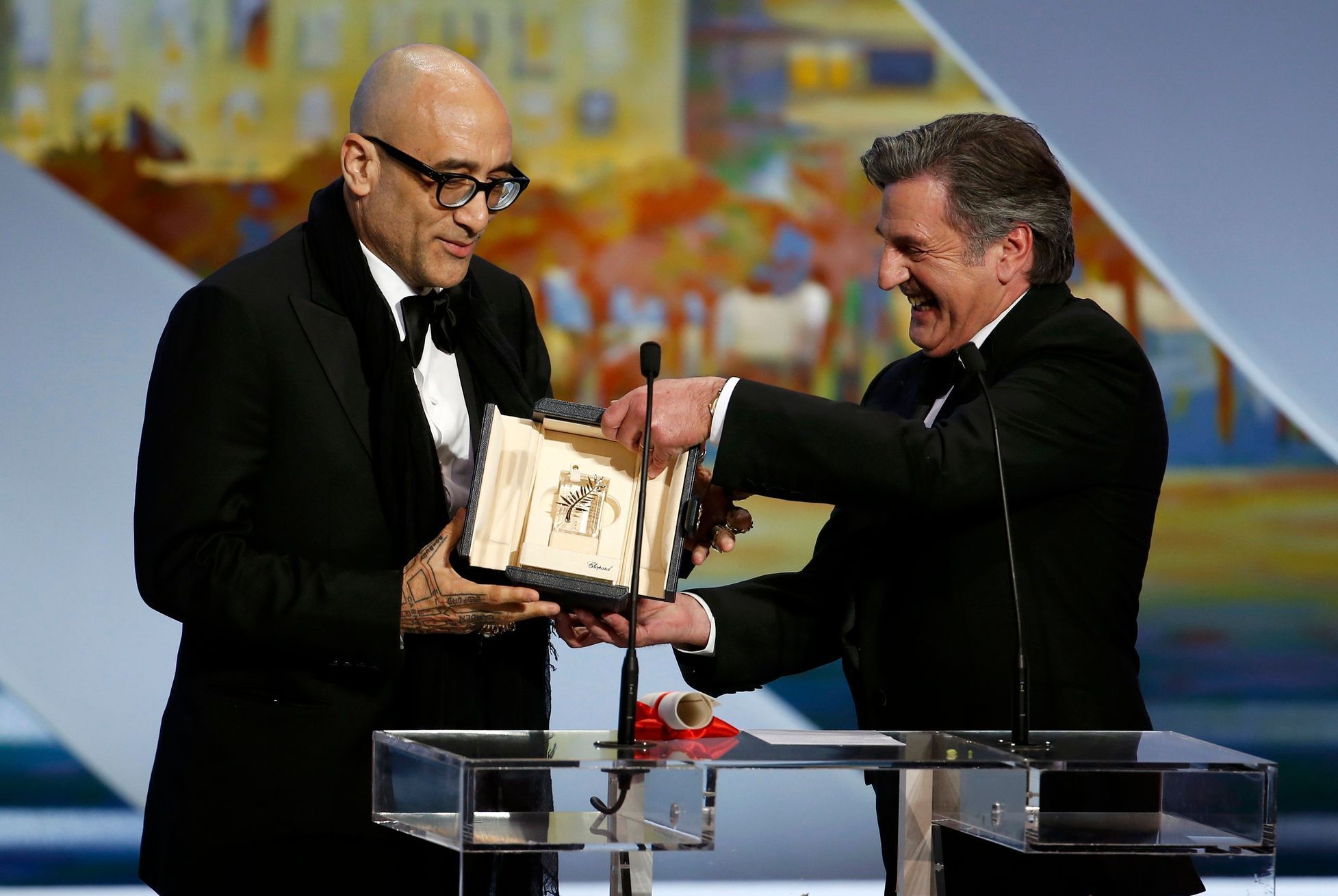 Screenwriter Bruce Wagner receives the Best Actress award on behalf of actress Julianne Moore, from actor Daniel Auteuil during the closing ceremony of the 67th Cannes Film Festival