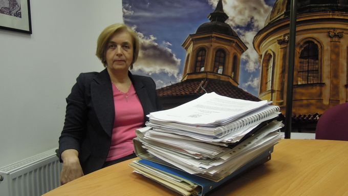 Jarmila Veselá se stohem dokumentů ke své nezákonné exekuci.