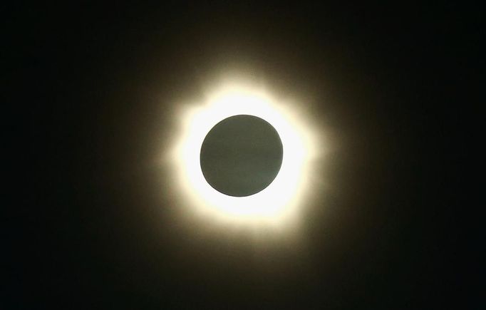 The moon passes in front of the sun during a full solar eclipse at Palm Grove near the northern Australian city of Cairns November 14, 2012. A rare full solar eclipse plunged north Queensland into darkness for two minutes early on Wednesday, delighting the thousands of people who had gathered on the Australian state's beaches. In Cairns, the main city in north Queensland and a gateway to the Great Barrier Reef, cloudy skies and occasional rain partly obscured the view, but elsewhere viewing conditions were more favourable. REUTERS/Tourism Queensland/Handout (AUSTRALIA - Tags: SOCIETY ENVIRONMENT) FOR EDITORIAL USE ONLY. NOT FOR SALE FOR MARKETING OR ADVERTISING CAMPAIGNS Published: Lis. 14, 2012, 1:54 dop.