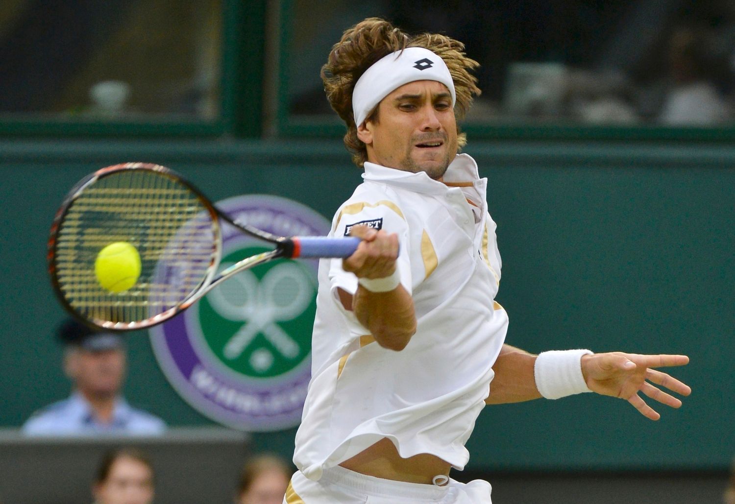 Španělský tenista David Ferrer odráží míček na Argentince Juana-Martína Del Potra během osmifinále Wimbledonu 2012.