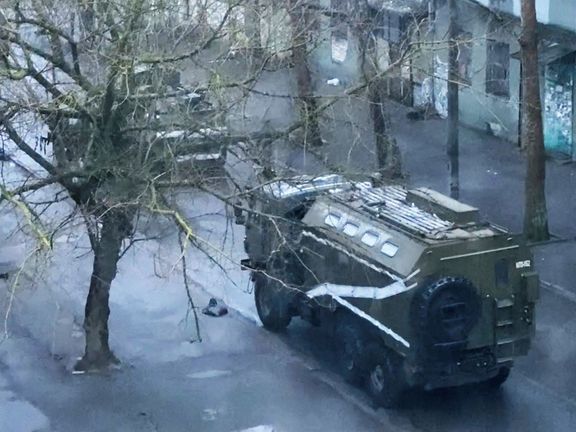 Vojenský automobil a tank na ulici v Chersonu na Ukrajině 1. března 2022. Výřez z videonahrávky.