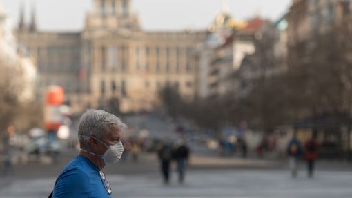 Muž s ochrannou maskou na obličeji se prochází po Václavském náměstí.
