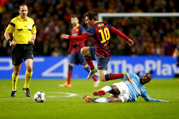 Manchester City's Yaya Toure challenges Barcelona's Lionel Messi during their Champions League round of 16 first leg soccer match at the Etihad Stadium in Manchester