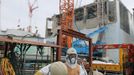 Workers stand in front of No.4 reactor of the Tokyo Electric Power Co (TEPCO)'s tsunami-crippled Fukushima Daiichi nuclear power plant in Fukushima prefecture, in this photo released by Kyodo March 1, 2013, ahead of the second-year anniversary of the March 11, 2011 earthquake and tsunami. Mandatory Credit REUTERS/Kyodo (JAPAN - Tags: DISASTER ANNIVERSARY BUSINESS) ATTENTION EDITORS - THIS IMAGE HAS BEEN SUPPLIED BY A THIRD PARTY. IT IS DISTRIBUTED, EXACTLY AS RECEIVED BY REUTERS, AS A SERVICE TO CLIENTS. FOR EDITORIAL USE ONLY. NOT FOR SALE FOR MARKETING OR ADVERTISING CAMPAIGNS. MANDATORY CREDIT. JAPAN OUT. NO COMMERCIAL OR EDITORIAL SALES IN JAPAN. YES Published: Bře. 1, 2013, 2:16 odp.