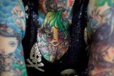 Další z žen ukazuje své tetování.
