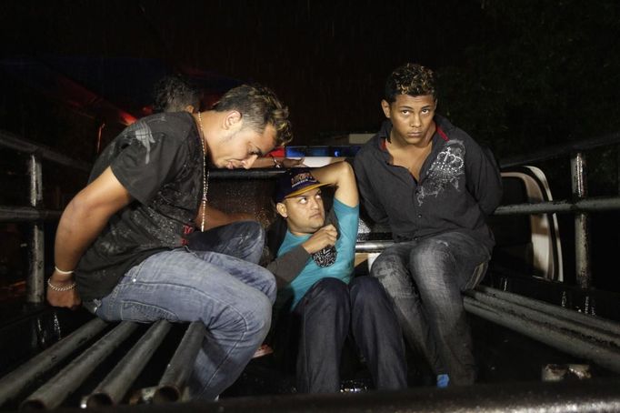 Suspected members of the Mara 18 street gang sit on a pick-up truck after their arrest after a shoot-out with police and military during an anti-drug operation in San Pedro Sula March 27, 2013. San Pedro Sula, the country's second largest city after Tegucigalpa, has a homicide rate of 169 per 100,000 people and was named the world's most violent city for a second year in a row. Lax laws allow civilians to own up to five personal guns, and arms trafficking has flooded the country with nearly 70% illegal firearms. 83.4% of homicides are by firearm compared to 60% in the United States. Picture taken March 27, 2013. REUTERS/Jorge Cabrera (HONDURAS - Tags: CRIME LAW CIVIL UNREST HEALTH) ATTENTION EDITORS: PICTURE 9 OF 39 FOR PACKAGE 'GUN CULTURE - HONDURAS' SEARCH 'HONDURAS GUN' FOR ALL IMAGES Published: Dub. 5, 2013, 11:14 dop.