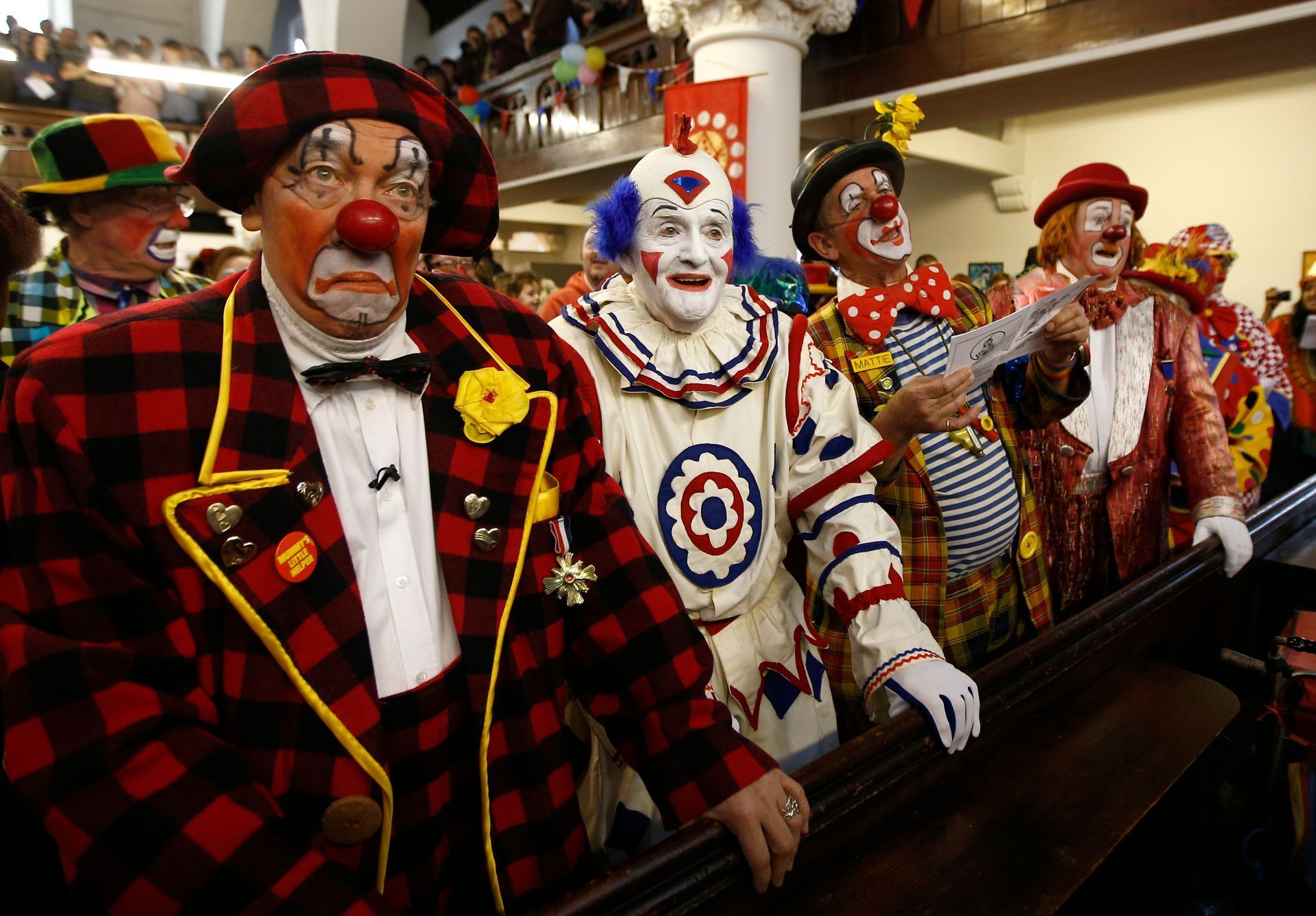 Clowns stand at the pews of the All Saints Church during the Grimaldi clown service in Dalston, north London