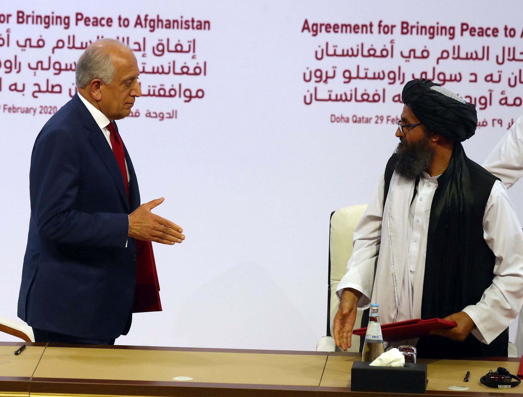 Zástupci USA a Tálibánu při podpisu dohody v Kataru.