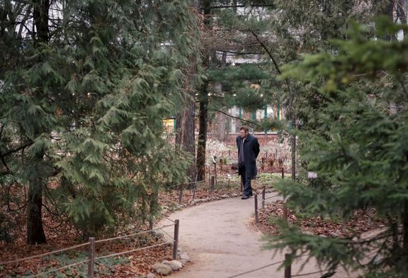 Lidé se procházejí botanickou zahradou moskevské univerzity. Je prosinec, nikde žádný sníh.