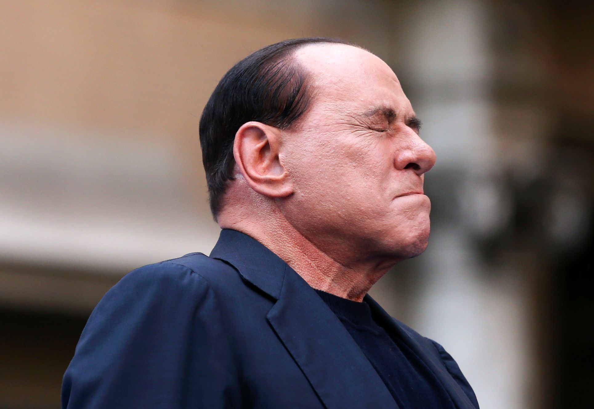 File photo of Berlusconi closing his eyes in a gesture to supporters during a rally to protest his tax fraud conviction, outside his palace in central Rome
