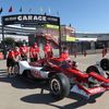Mechanici tlačí monopost Marcuse Ericssona do boxů v závodě IndyCar na Texas Motor Speedway