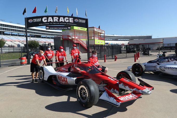 Mechanici tlačí monopost Marcuse Ericssona do boxů v závodě IndyCar na Texas Motor Speedway