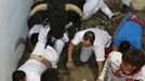 A Miura fighting bull steps on a fallen runner at the entrance to the bullring during the second running of the bulls of the San Fermin festival in Pamplona July 8, 2012. There were no injured runners in the run that lasted two minutes and twenty nine seconds, according to local media. REUTERS/Susana Vera (SPAIN - Tags: ANIMALS SOCIETY) Published: Čec. 8, 2012, 8:06 dop.