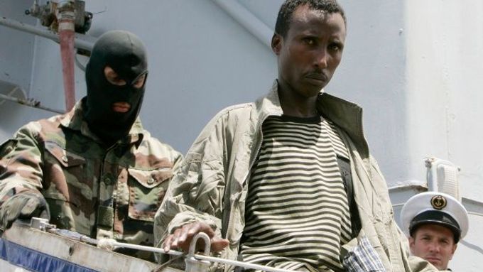 Policista hlídá zadržené piráty, kteří budou předáni keňským úřadům, aby mohli být souzeni