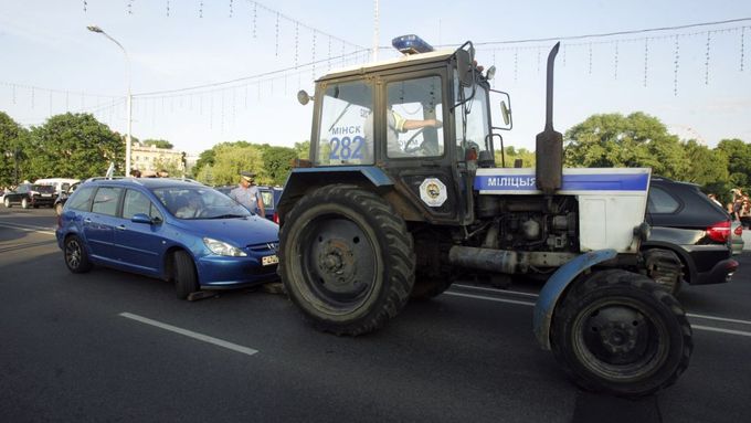 Policejní traktor odstraňuje ze silnice jednoho z účastníků protestní blokády.