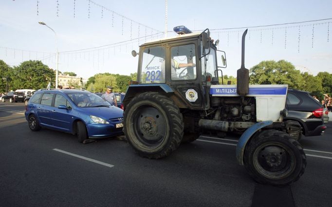 Policejní traktor odstraňuje ze silnice jednoho z účastníků protestní blokády.