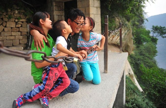 Legless Man Ascends Huashan Mountain By Arms HUAYIN, CHINA - AUGUST 13: (CHINA OUT) Legless man Chen Zhou pose with his family as he climbs the Huashan Mountain on August 13, 2012 in Huayin, Shaanxi Province of China. Legless 29-year-old man Chen Zhou from Cangshan of Shandong Province spent two days, 19 hours in total, climbing by arms to the top of Huashan Mountain. Chen lost his legs after falling off a train at the age of 13, but he has since strived to be stronger and joined in many public performances to encourage other people. Chen Zhou will climb the Taishan Mountain in Shandong province in the following months. ( automatický překlad do češtiny )