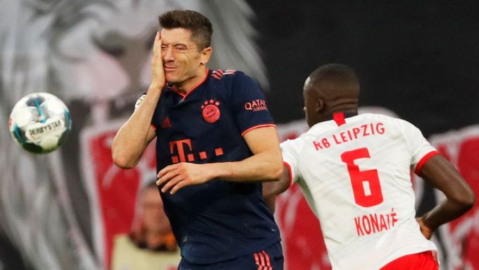 Útočné eso mnichovského Bayernu Robert Lewandowski se drží za tvář po souboji s Ibrahimou Konatém z Lipska